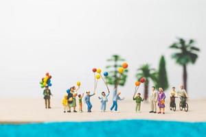 miniatyr människor njuter av sommarsemester på stranden foto