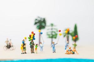 miniatyr människor njuter av sommarsemester på stranden foto