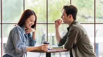 unga asiatiska par daterar på kafé foto