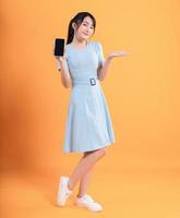 ung asiatisk kvinna bär klänning på bakgrund foto