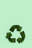 grön mossa under papper skära återvinning symbol. spara planet, eko, återvinning begrepp foto