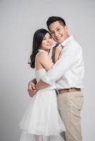 lyckliga asiatiska par i kärlek på grå bakgrund foto
