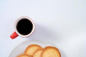röd kaffekopp med kakor på vit bakgrund foto