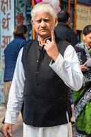 ny delhi, Indien - december 04 2022 - oidentifierad människor som visar deras bläckmärkt fingrar efter gjutning röster i främre av polling bås av öst delhi område för mcd lokal- kropp val 2022 foto