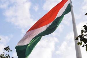 Indien flagga vajar högt på connaught plats med stolthet över blå himmel, Indien flagga vajar, indiska flaggan på självständighetsdagen och republikens dag i Indien, tilt up shot, viftande indiska flaggan, har ghar tiranga foto