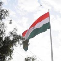 Indien flagga vajar högt på connaught plats med stolthet över blå himmel, Indien flagga vajar, indiska flaggan på självständighetsdagen och republikens dag i Indien, tilt up shot, viftande indiska flaggan, har ghar tiranga foto