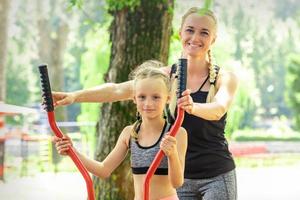 mor med dotter håller på med sport övningar foto