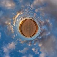 mycket liten planet i blå mulen kväll himmel med skön moln med omvandling av sfärisk panorama 360 grader. sfärisk abstrakt antenn se. krökning av Plats. foto