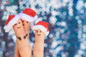 fingrar konst av familj firar jul. begrepp av grupp av människor leende i ny år hattar. foto