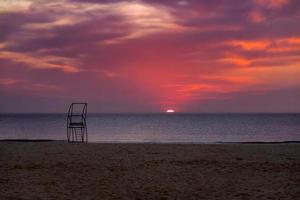 gammal rädda posta på de strand på en bakgrund av de hav på solnedgång foto
