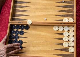 en man rör sig en slå samman i en backgammon spel foto