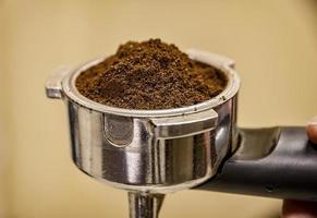 stänga upp av Barista innehav portafilter för espresso kaffe maskin. espresso förberedelse. foto