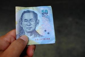 femtio thai baht pengar i hand för betalning. foto