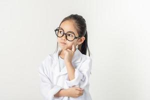 smart läkare liten flicka med vit medicinsk täcka foto