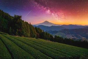 landskap med mjölkig sätt galax. mt. fuji över grön te fält med höst lövverk och mjölkig sätt på soluppgång i shizuoka, japan. foto