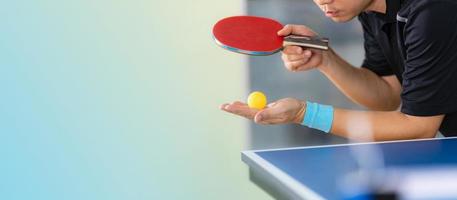 man spelar bordtennis med racket och boll i en sporthall foto