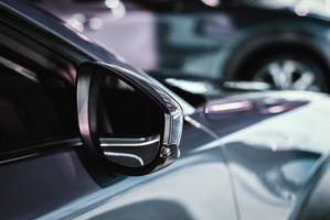 bilar i återförsäljare showroom, bil sida spegel med sväng signal, grå bakgrund foto