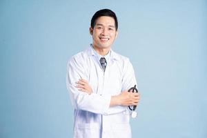 asiatisk manlig läkare porträtt på blå bakgrund foto