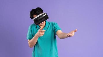 bild av asiatisk man bär virtuell verklighet glasögon på lila bakgrund foto