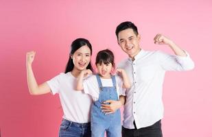 Lycklig ung asiatisk familj bild, isolerat på rosa bakgrund foto