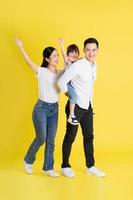 Lycklig asiatisk familj bild, isolerat på gul bakgrund foto