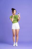 full kropp bild av skön asiatisk flicka Framställ på rosa bakgrund foto