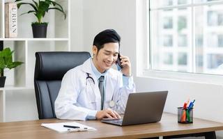 asiatisk manlig läkare porträtt Sammanträde på arbete foto