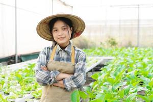 bild av asiatisk kvinna jordbrukare i henne hydroponiska vegetabiliska trädgård foto