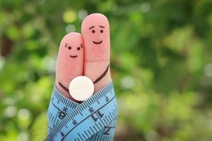 fingrar konst av Lycklig par. de begrepp av en man och en kvinna på de piller för vikt förlust. foto