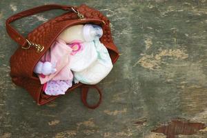 mors handväska med objekt till vård för barn. foto