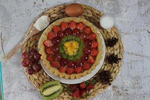 stor frukt paj med pålägg av jordgubbar, vindruvor, kiwi och ananas. välsmakande, ljuv och färsk. mat begrepp Foto. foto