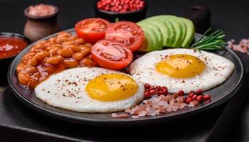 utsökt näringsrik engelsk frukost med friterad ägg, tomater och avokado foto