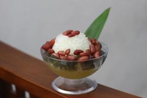 es kacang Merah eller en kall dryck tillverkad från röd bönor kokt med brun socker eras med kokos mjölk, rakat is och täckt med sötad komprimerad mjölk choklad och sirap. foto