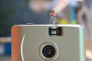 miniatyr- figur av en videographer inspelning på ett analog kamera. foto