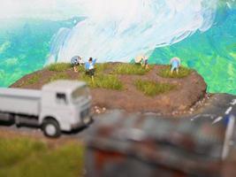 en miniatyr- diorama av en ris fält och en väg som väl som flera människor och fordon och byggnader. foto