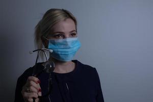 närbild av en kvinna sjukvård professionell sjuksköterska bär en skydd mask foto