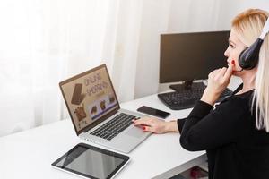 kvinna handla uppkopplad använder sig av henne bärbar dator på Hem foto