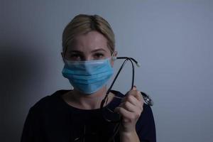 närbild av en kvinna sjukvård professionell sjuksköterska bär en skydd mask foto