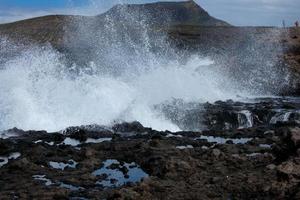 stor vågor kraschar mot de stenar i de hav foto