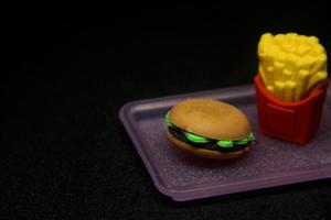 hamburgare och frites formad suddgummi. skola eller kontor stationär verktyg leveranser med skräp mat form. isolerat Foto på mörk svart bakgrund.