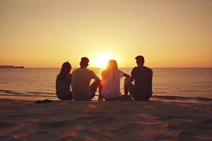 grupp av fem Lycklig människor sitter på bakgrund av tömma solnedgång strand. resa eller hav semester begrepp foto