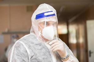 en manlig läkare i en skyddande mask och kostym i de korridor av de sjukhus med en coronavirus infektion. foto