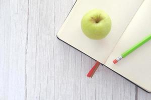 äpple i ett anteckningsblock på bordet foto