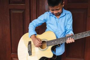 unge som spelar en gitarr foto