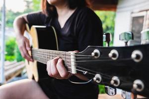 närbild av en kvinna som spelar gitarr foto