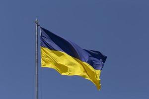 vinkade ukrainska flagga hängande på metallisk flaggstång foto