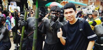 loei, thailand-juli 6, 2022 phi ta khon eller spöke festival. asiatisk turist tar Foto med lokal- människor i färgrik Kläder och spöke mask för berömd kultur traditionell på juli av varje år.