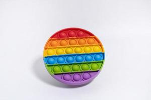flerfärgad anti-stress leksak. enkel grop i regnbåge färger på vit bakgrund foto