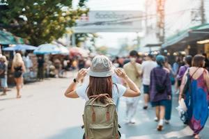 kvinna resande besöker i Bangkok, turist med ryggsäck och hatt sightseeing i chatuchak helgen marknadsföra, landmärke och populär attraktioner i Bangkok, thailand. resa i sydöst Asien begrepp foto