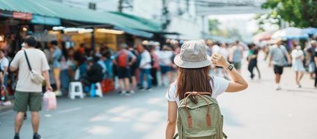 kvinna resande besöker i Bangkok, turist med ryggsäck och hatt sightseeing i chatuchak helgen marknadsföra, landmärke och populär attraktioner i Bangkok, thailand. resa i sydöst Asien begrepp foto